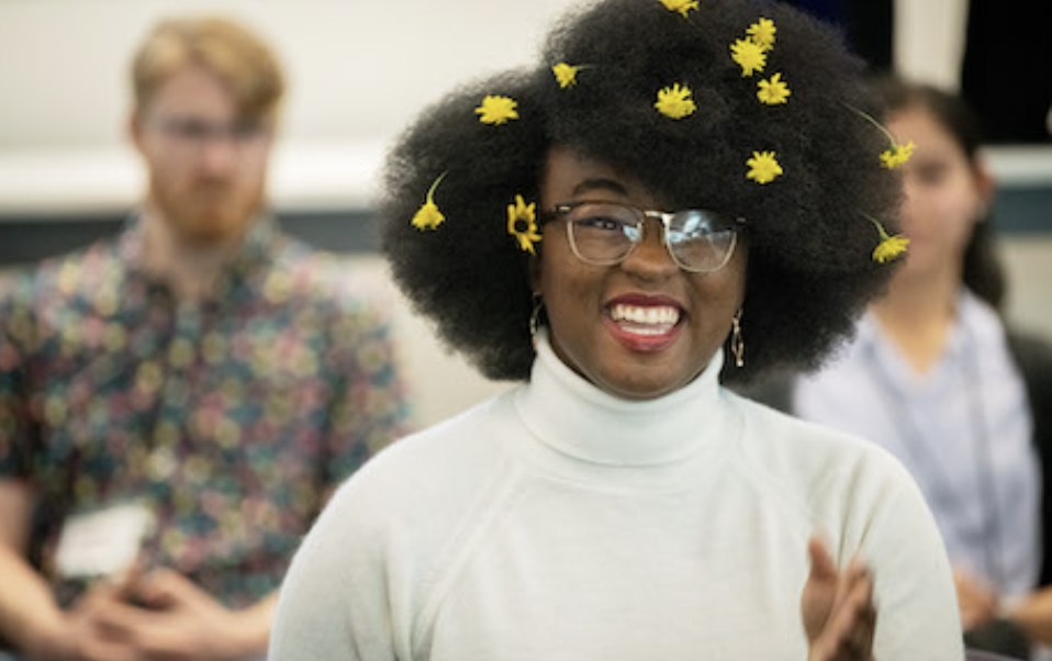 Smiling young businessman working online with digital tablet while standing by window.
